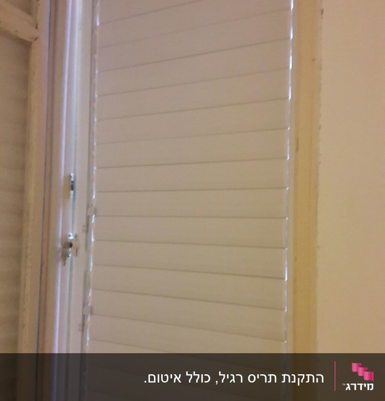 תריסי אלומיניום לבנים על חלון